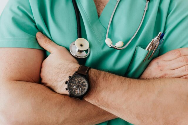 Profesional de la salud con uniforme médico y estetoscopio, representando respaldo y confianza en seguros de salud.