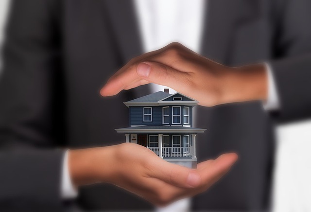 Casa protegida por manos, símbolo de protección financiera, seguro de hogar y respaldo patrimonial.