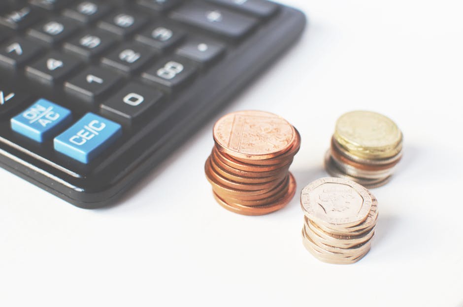 Monedas y calculadora simbolizando estrategia financiera, presupuesto y protección económica en seguros.